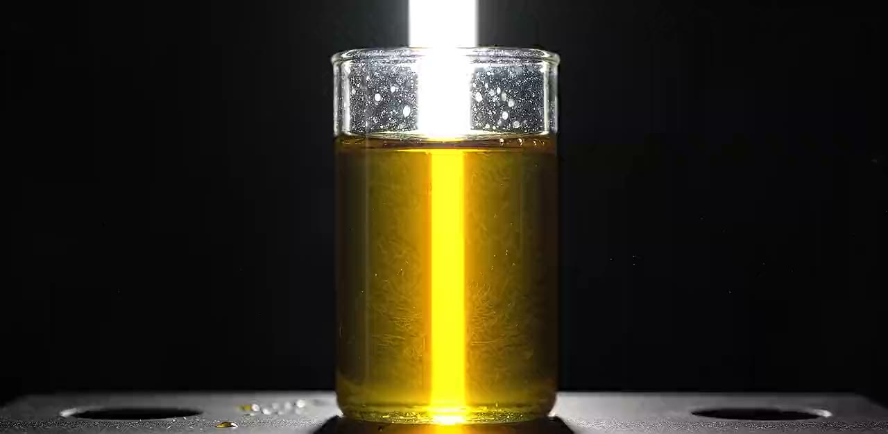 A sample cell of refined rice bran oil, backlit and clear